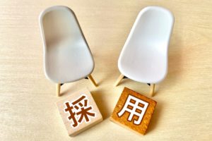 白い椅子と採用と書かれた正方形の木の板